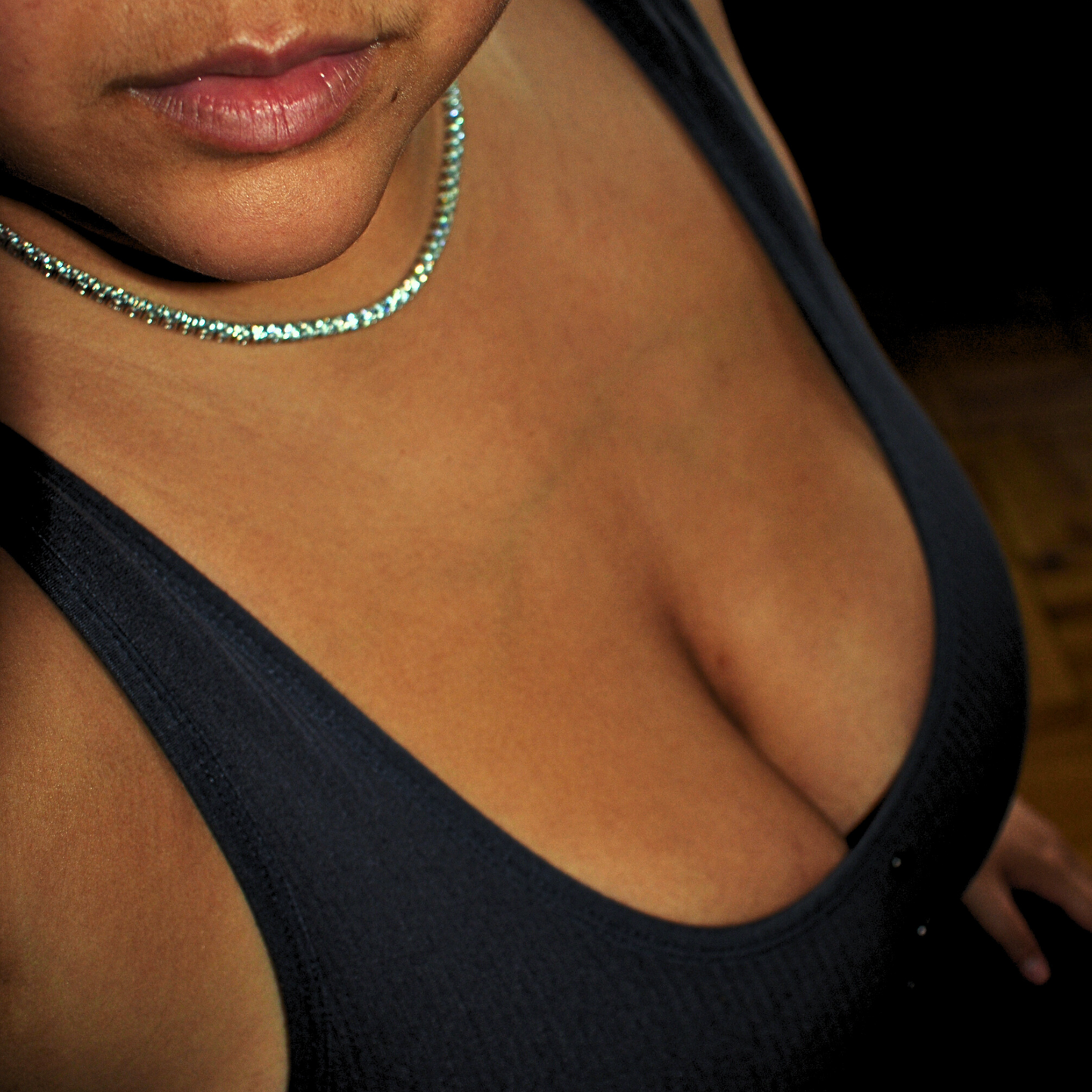 Upscale Moissanite tennis chain necklace, showcasing VVS clarity stones, worn elegantly with a black top.
